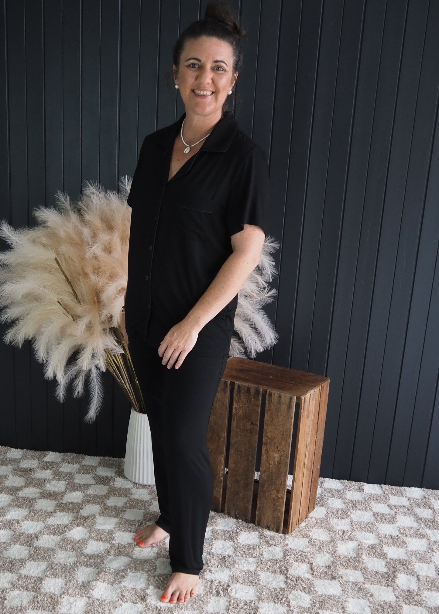 Woman wearing Phebe black bamboo pyjama set with short sleeves and long pants