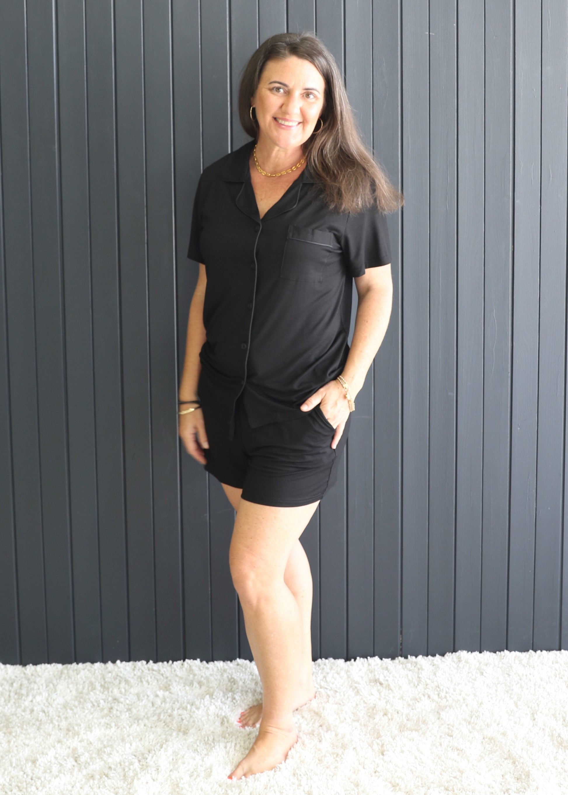 Woman wearing black bamboo short PJ set with button-up top and shorts – front view